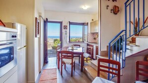 A kitchen with a dining area, a staircase, and a view of the sea. - Gorgeous home in Petrizzi with house sea view (Petrizzi)