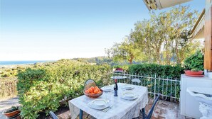 An outdoor dining area with a table set for two, overlooking a scenic view of hills and the sea. - Gorgeous home in Petrizzi with house sea view (Petrizzi)