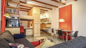 A compact living space with a kitchenette, a dining area, and a seating area with a sofa and chairs. - 1 bedroom beach front home in Enkhuizen (Enkhuizen)
