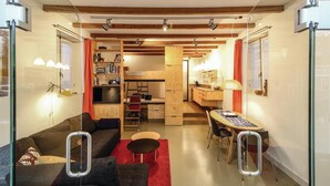 A compact living space with a sofa, a dining table, and a kitchenette. - 1 bedroom beach front home in Enkhuizen (Enkhuizen)