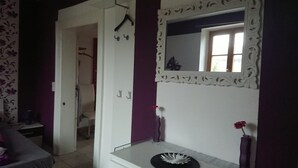 A room with a white vanity, a mirror with an ornate frame, and a purple wall.