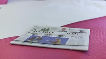 A newspaper on a pink surface.
