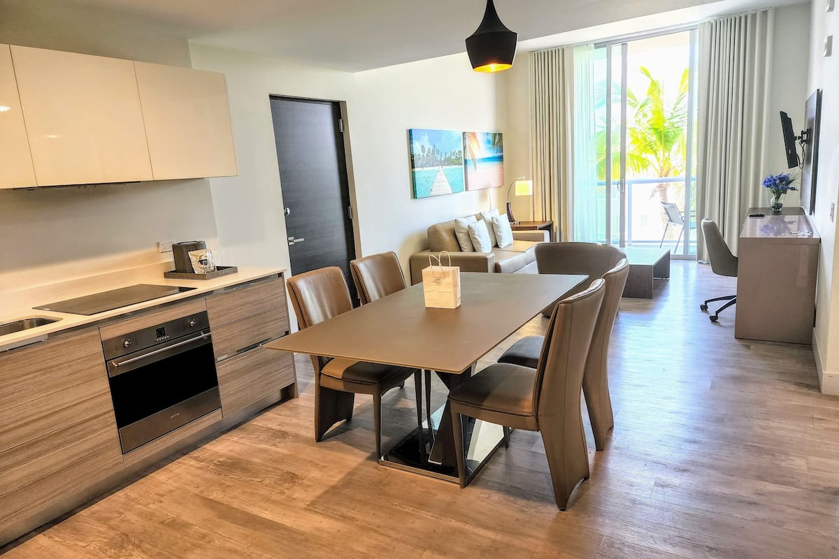 Une cuisine moderne avec un coin repas, un canapé et un bureau avec un ordinateur.