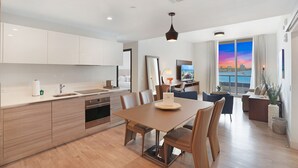 Una cocina moderna con comedor, ventanas amplias con vista a la ciudad y un espacio de sala acogedor.