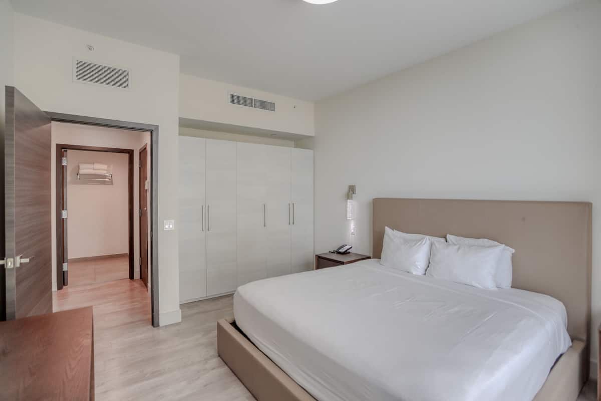 Une chambre à coucher moderne avec un grand lit, une table de chevet et une armoire.