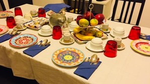 Una mesa de comedor dispuesta con platos, tazones, tazas y cubiertos.