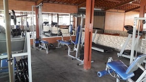 A gym with various exercise equipment, including weight benches and a squat rack. - Porto Praia Hotel (Barra dos Coqueiros)