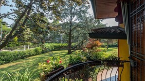 Un jardín con barandilla metálica, un sendero y diversas plantas.
