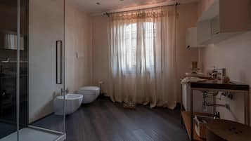 Ein modernes Badezimmer mit Duschabtrennung aus Glas, Doppeltoilette und Waschtisch mit Becken und Spiegel.