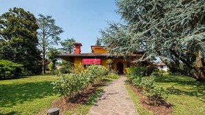Una casa con un camino de piedra que lleva a la entrada, rodeada de follaje y árboles.