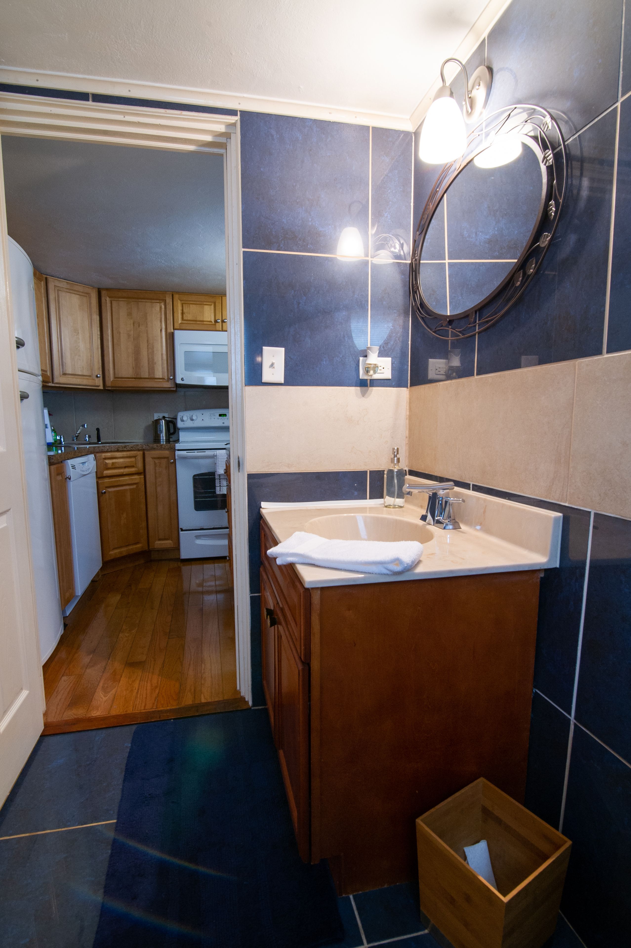 A compact kitchen with wooden cabinets, a white dishwasher, and a built-in oven.