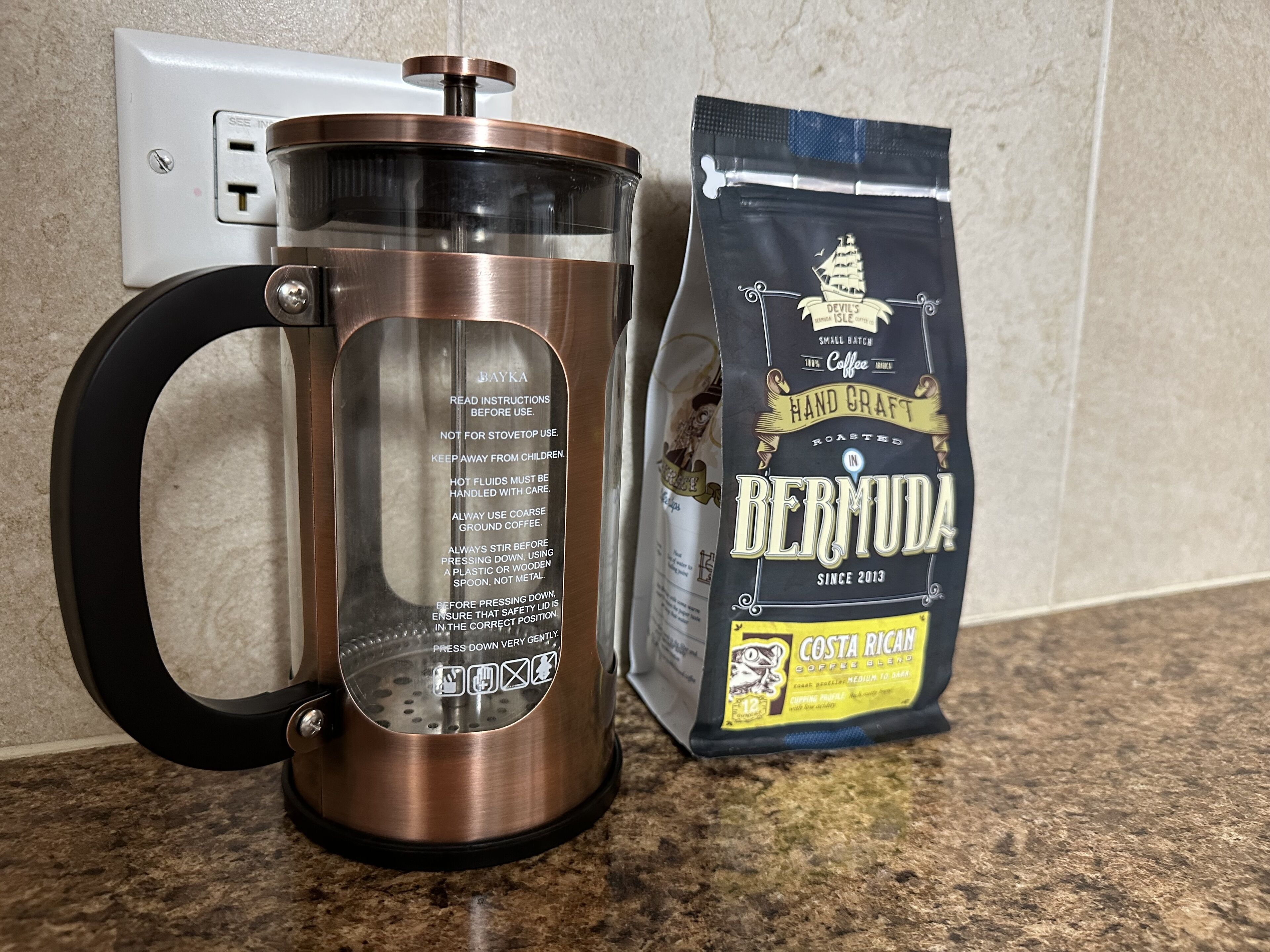A coffee maker and a bag of coffee beans on a kitchen counter.