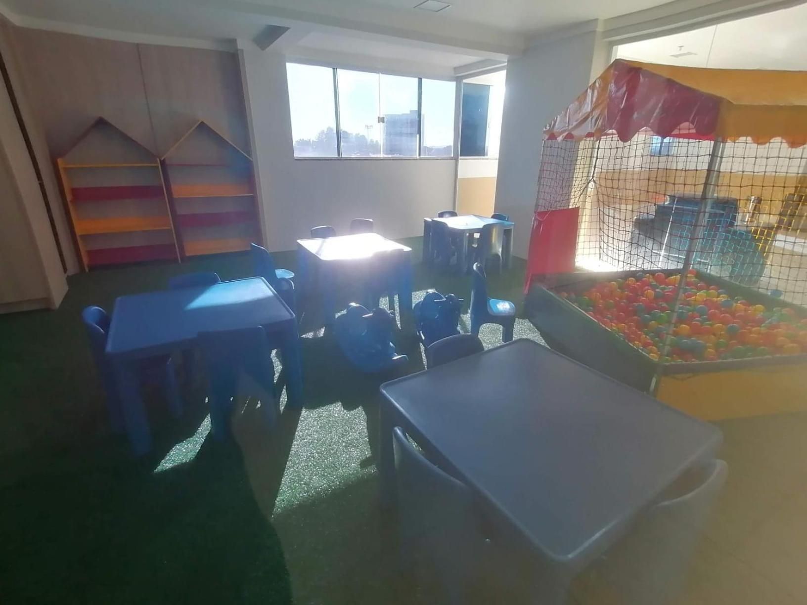 A children's play area with tables, chairs, and a ball pit.