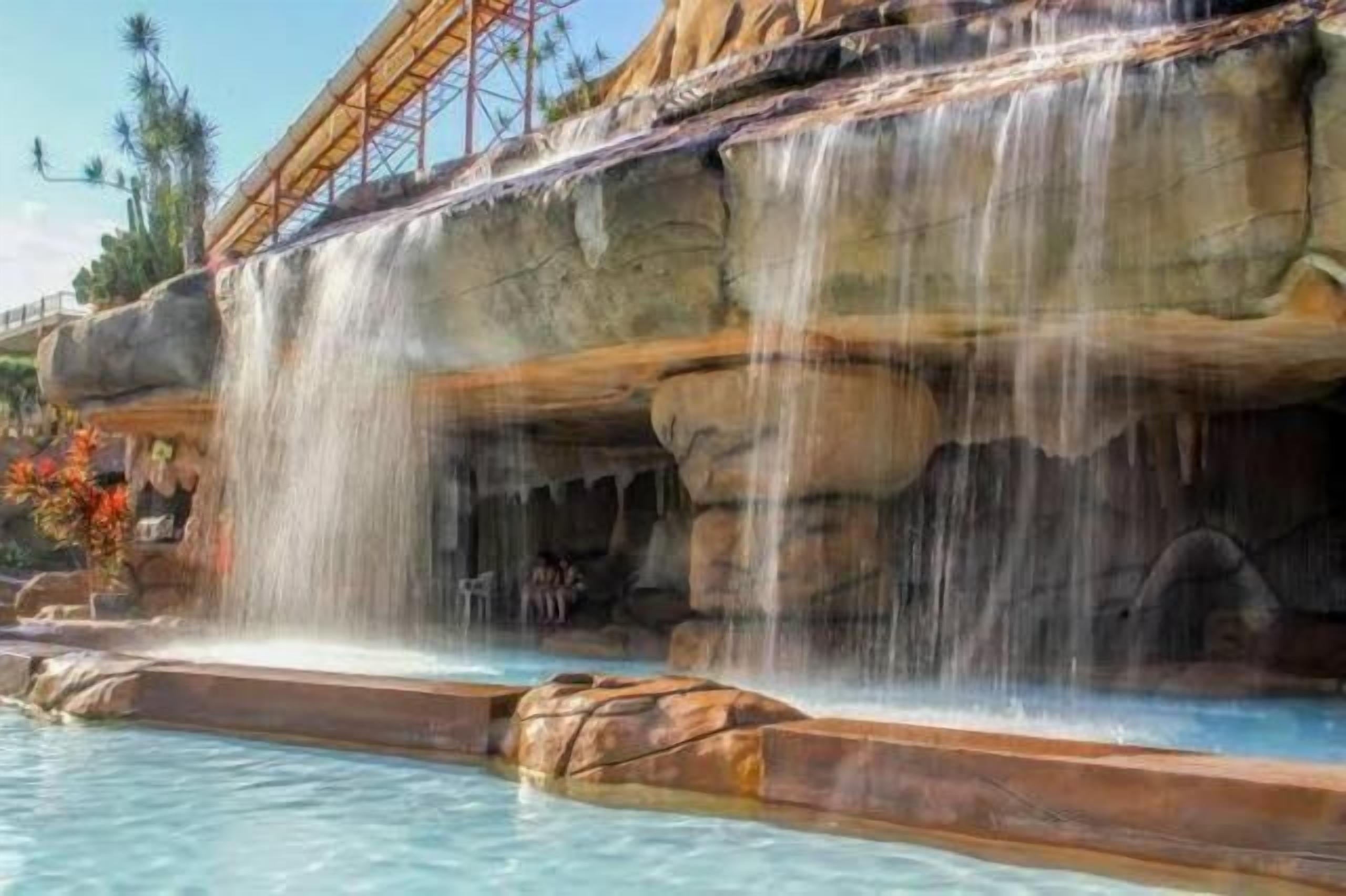 A water feature with a waterfall and pool, surrounded by rock formations.