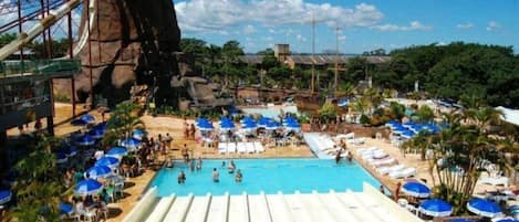 Una piscina al aire libre, sillones reclinables de piscina