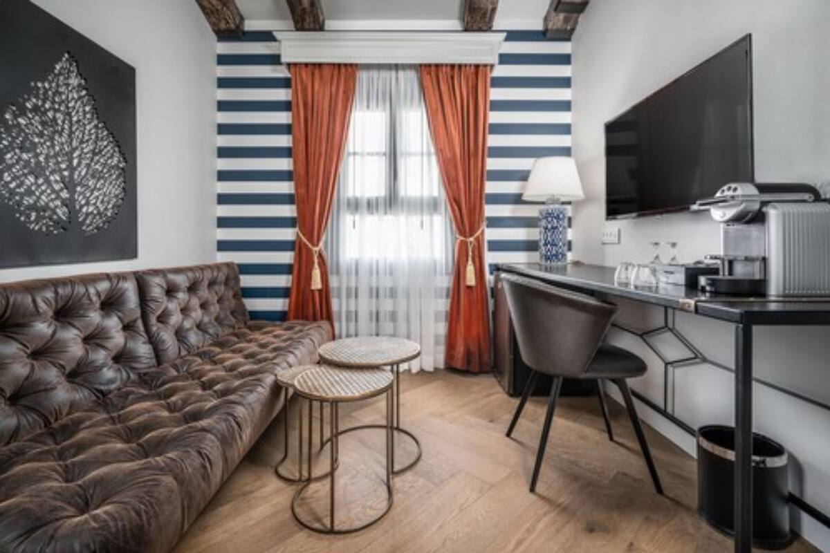 A modern living room with a leather sofa, a small round table, and a TV.