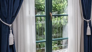 A room with a sliding glass door leading to a garden.