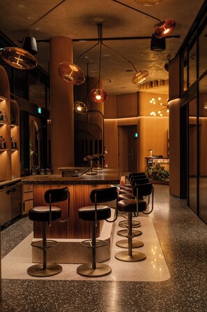 A bar area with a central island, bar stools, and pendant lighting. - Orange Grove Serviced Residences (Singapore)