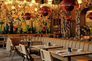 A restaurant with booth seating, tables, and hanging lamps.