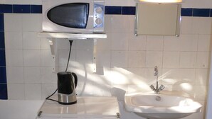 A compact kitchenette with a microwave, coffee maker, and sink. - Beautiful bright room (Le Mesnil-Esnard)