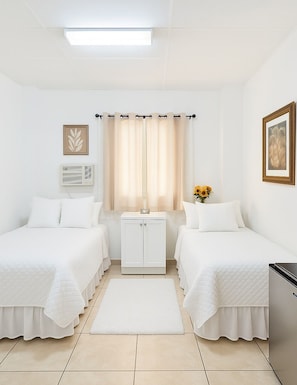 Two single beds with white bedding and a minimalist design.