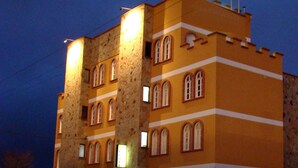 Un edificio de varios pisos con fachada de piedra y múltiples ventanales de arco.
