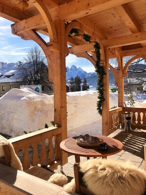 A wooden gazebo with a table and a dog. - COOEE alpin Apartments Gosau (Gosau)