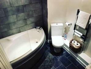 Une salle de bain avec une baignoire, des toilettes et un bidet.