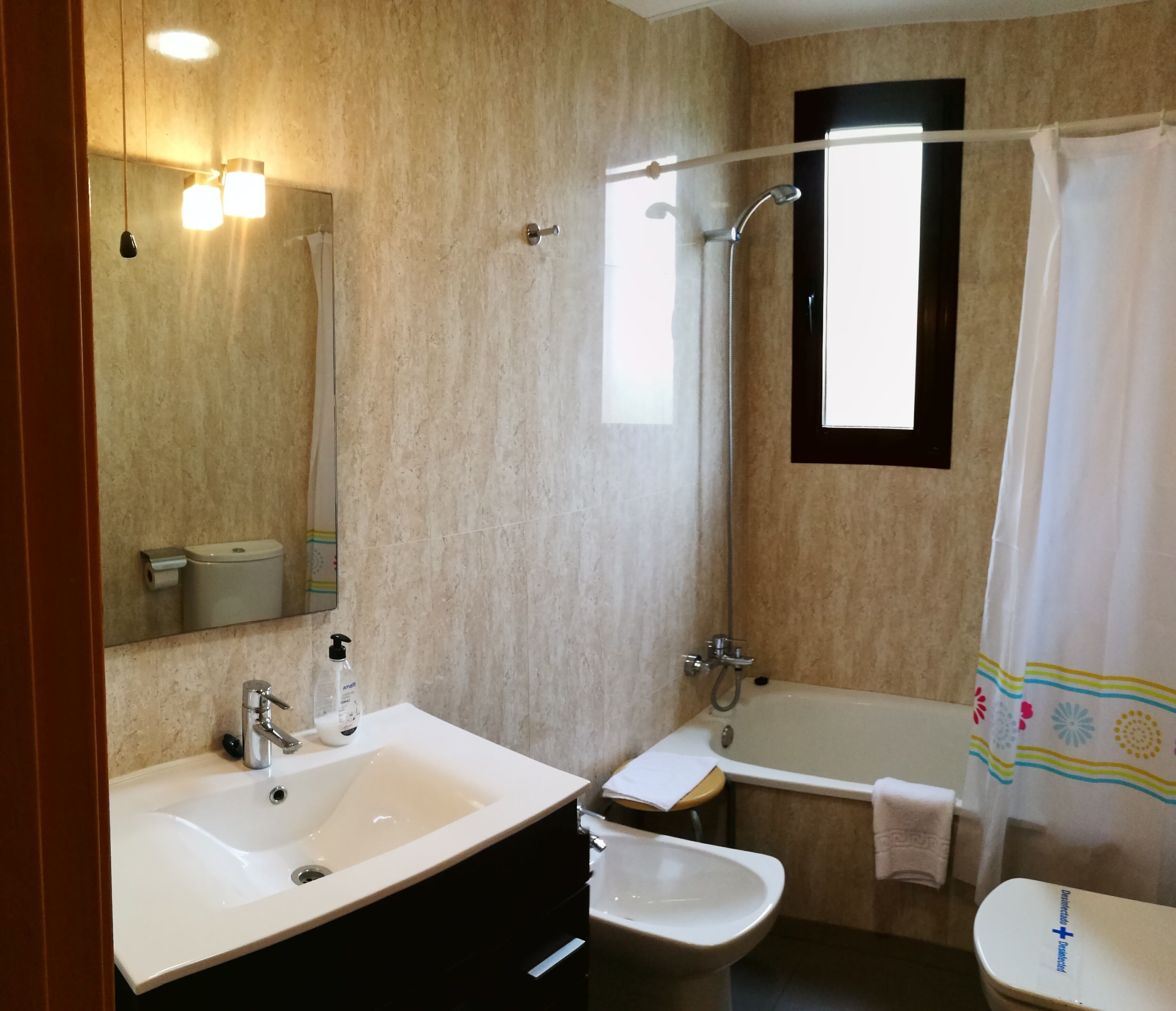 Un baño con dos lavamanos, una bañera, una ducha y un inodoro.