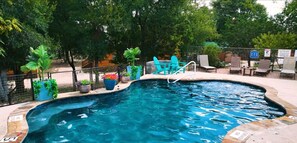 Relax by the pool surrounded by lush greenery and comfortable lounge chairs.