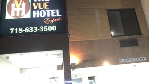 Un letrero de hotel con el nombre "The Vue Hotel Express" y un número de teléfono.