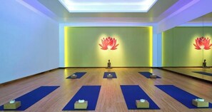 A yoga studio with a wooden floor, blue mats, and a lotus symbol on the wall. - Charlie Rentz: Gondola, Private Patio, Resort Amenities, BC Views, Ski Valet + Pool (Avon)