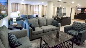 A modern living room with grey sofas, a coffee table, and a TV in the background. - New Capitol Hotel - Jerusalem (Jerusalem)