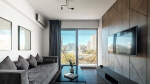 A modern living room with a sofa, coffee table, and a flat-screen TV mounted on the wall. - Nido x Quartier Dorrego (Buenos Aires)