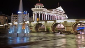 A historic building with a central dome and a fountain in front. - Hotel Square (Skopje)