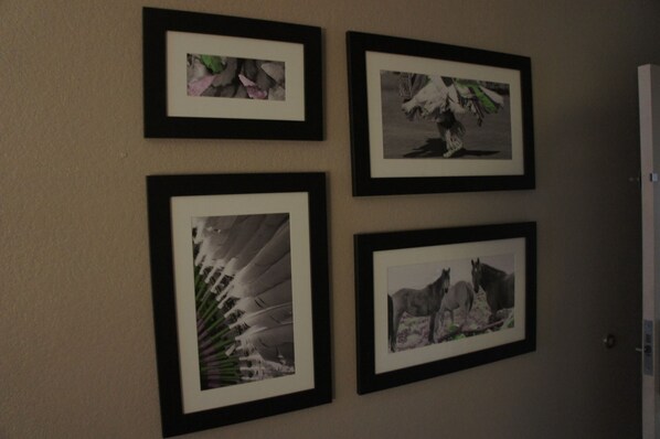 Vier ingelijste foto's aan een muur.