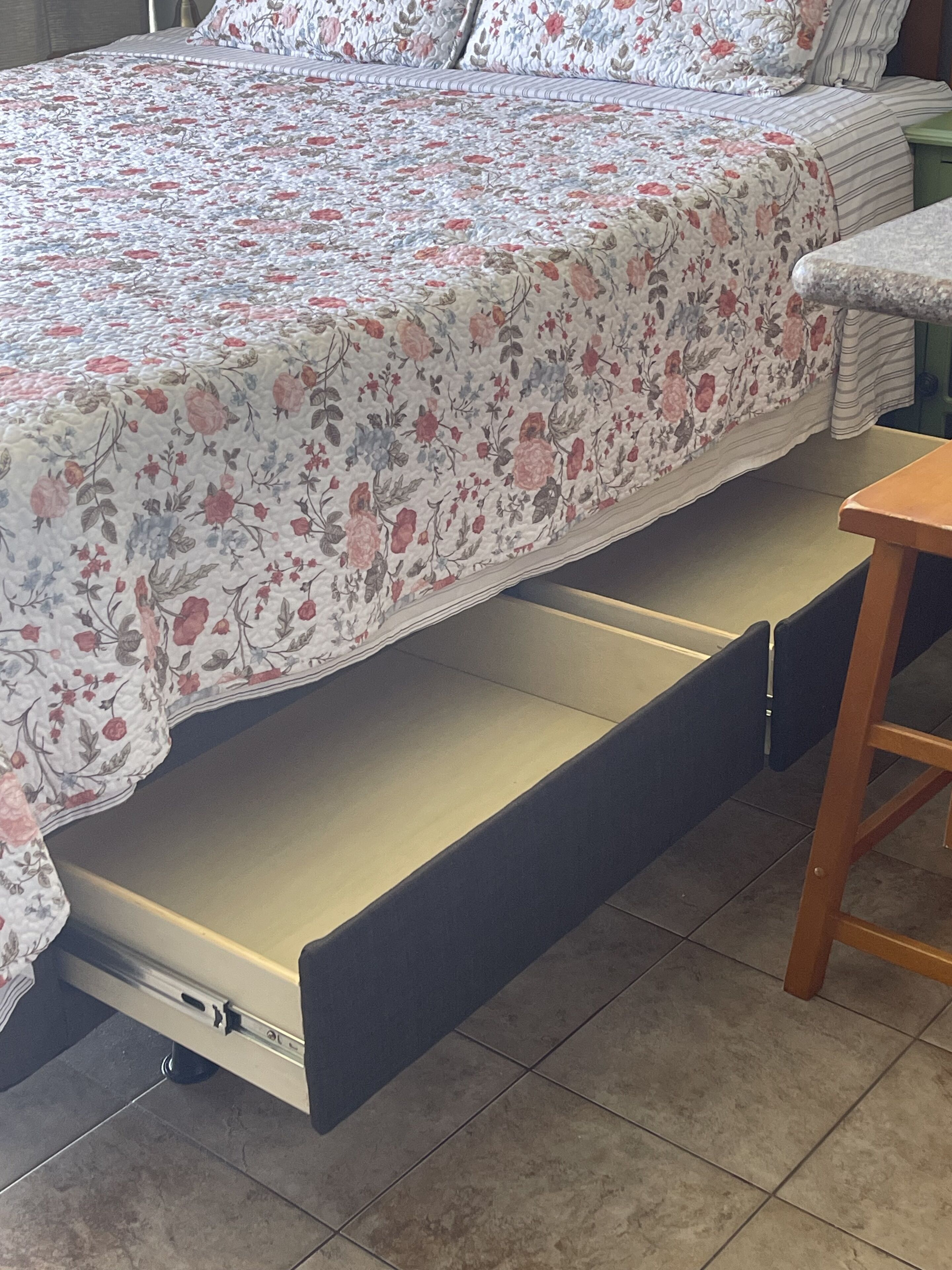 Una cama con una colcha estampada y un compartimento oculto debajo del colchón.