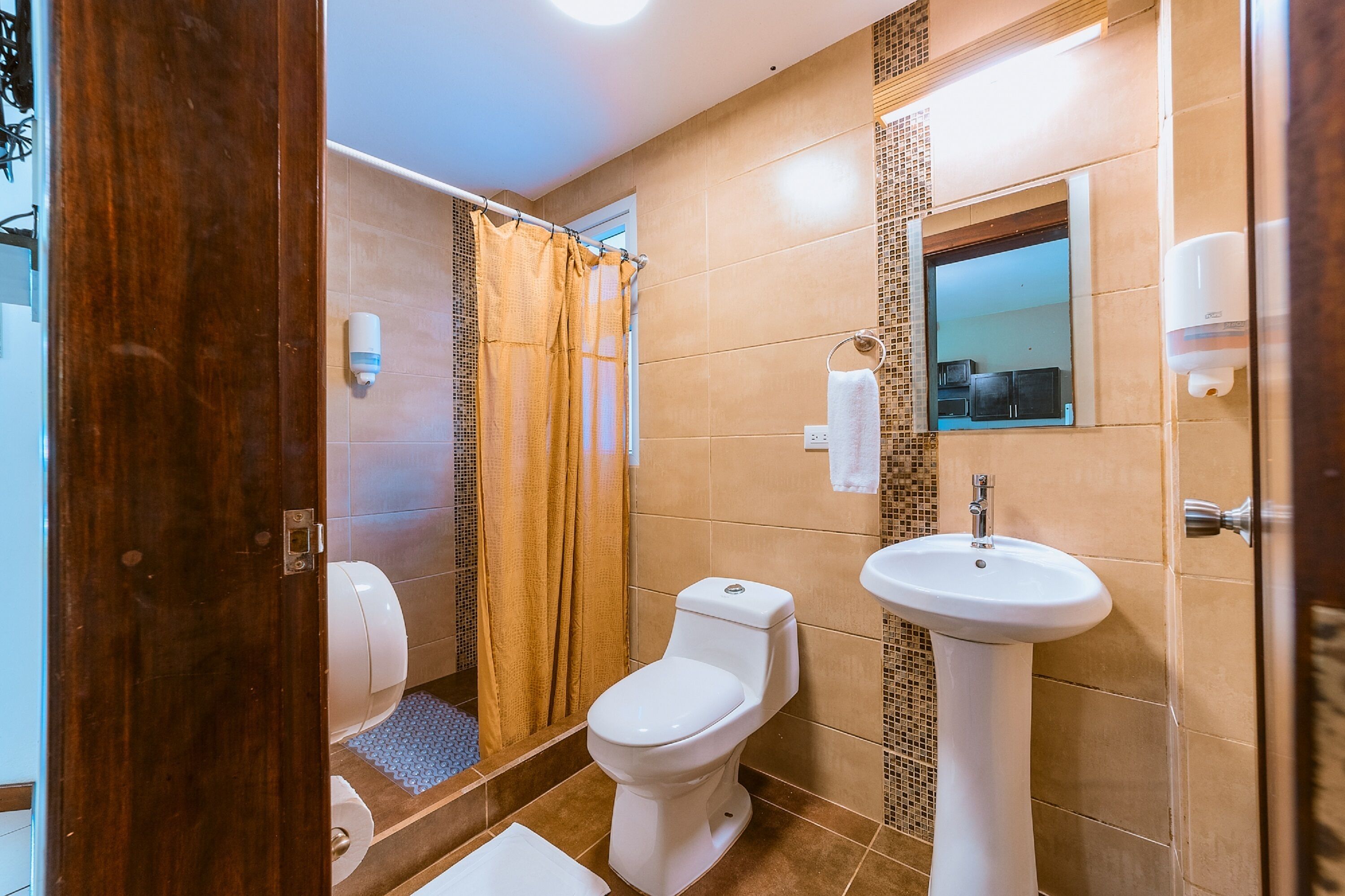 A bathroom with a toilet, shower, and sink.