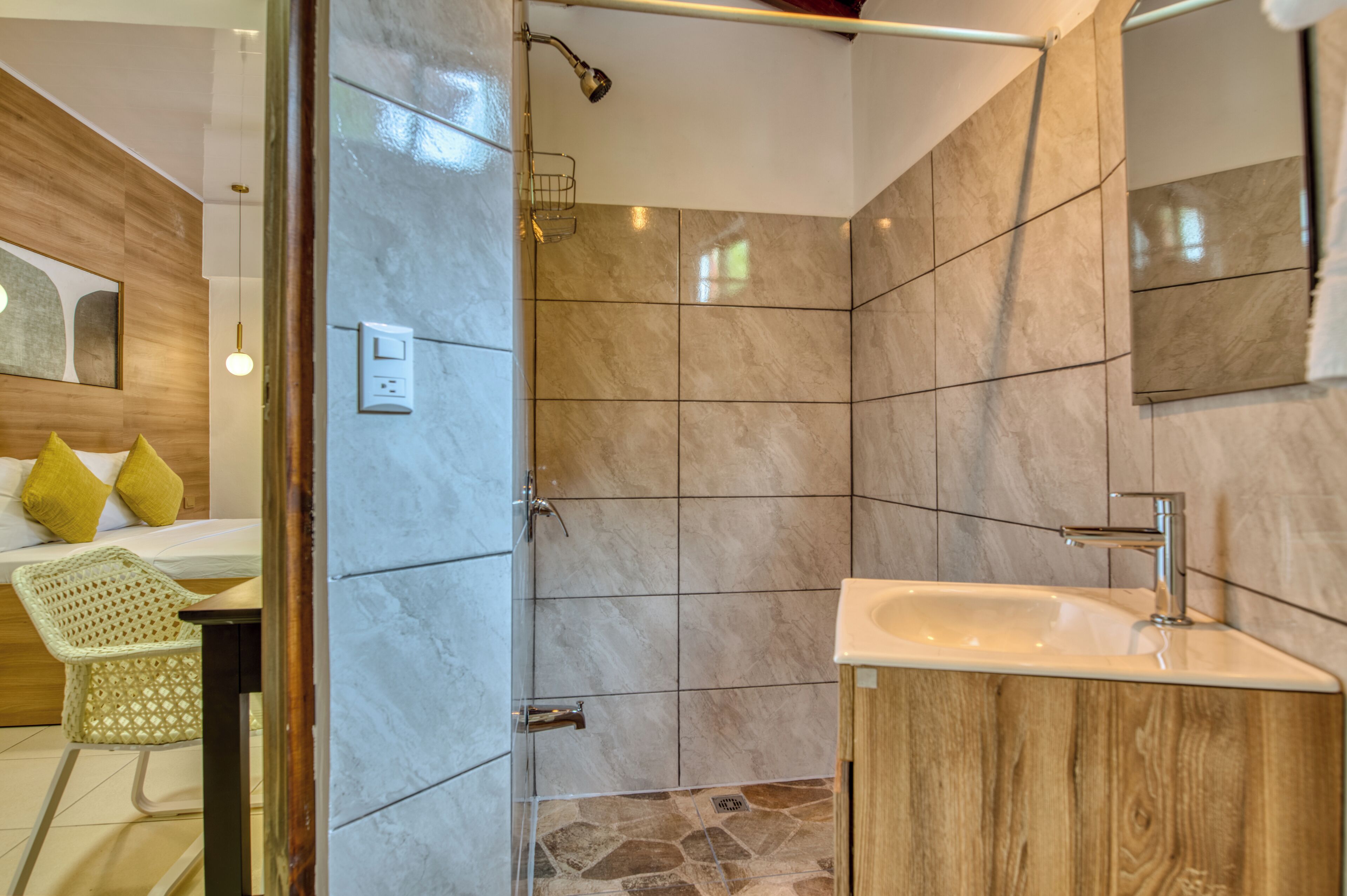 Un baño moderno con ducha, lavamanos y tocador de madera.