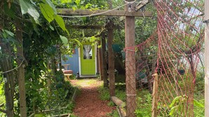 A garden pathway with a wooden pergola and climbing plants.