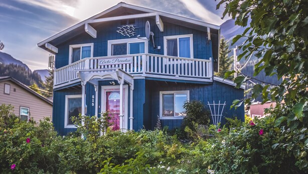A two-story house with a balcony, a satellite dish, and a sign reading "Arctic Paradise."