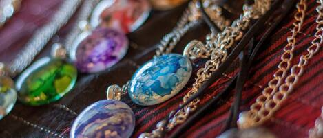 A collection of colorful gemstones and jewelry on a fabric background.