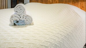 A neatly made bed with a textured white bedspread and rolled white towels on top. - 2 Bedroom In Indian Rocks Beach, FL - Gulf Side Complex w/ Direct Beach Access (Indian Rocks Beach)