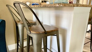 A kitchen area with a bar stool and a counter. - 2 Bedroom In Indian Rocks Beach, FL - Gulf Side Complex w/ Direct Beach Access (Indian Rocks Beach)