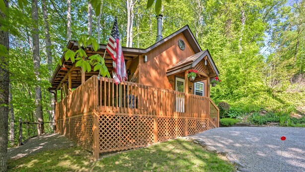 A wooden cabin with a deck, surrounded by trees. -  HOT TUB,WIFI, JACUZZI, FIRE PIT, ~A/C~ CREEK, 2 MIN TO MAGGIE (Maggie Valley)