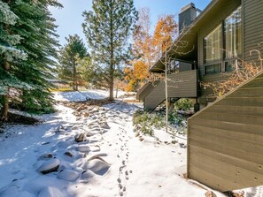 A snow-covered path leading to a wooden building with a sloped roof and large windows. - Ski the greatest snow on earth! (Park City)