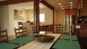 A dining area with a wooden table, green placemats, and a large bowl centerpiece. - 3 Bed 2 Bath Ocean View Home (Carlsbad)