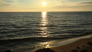 Uma praia com o sol refletindo na água.