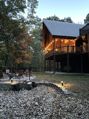 A wooden cabin with a covered deck and outdoor seating area.