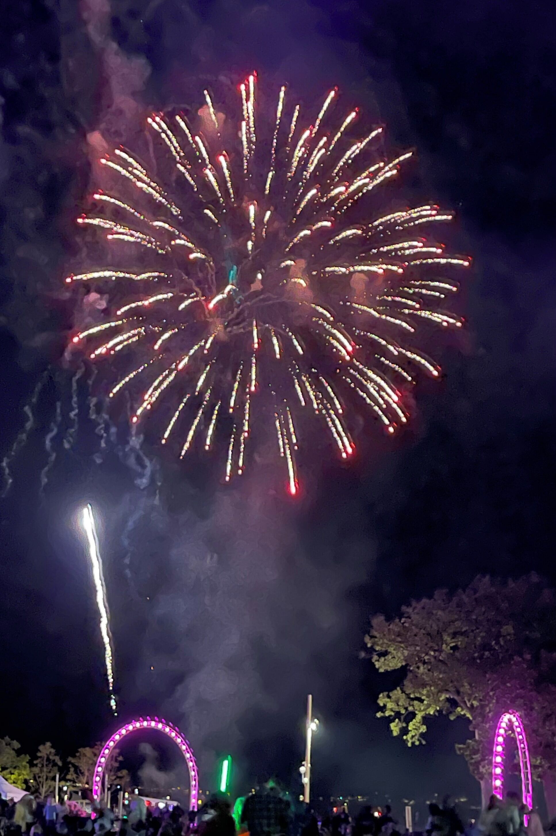 Een nachtelijke scène met vuurwerk en verlichte bogen.
